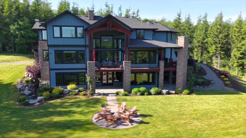 This view is hard to beat- showcasing the grand presence of the three-story custom home beautifully illuminated at night, with a private fire pit thoughtfully designed for evenings under the stars.